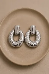 Aros de estilo vintage con diseño de argolla martillada y pieza superior lisa en acabado dorado brillante.