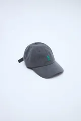 Gorra gris de lona con visera curva y pequeño bordado verde en el frente que incluye una estrella y dos líneas horizontales.