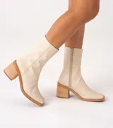 Bota de cuero vacuno color marrón con cierre lateral, taco de madera de 7cm y caña de 19cm.