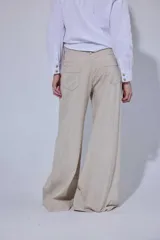 Pantalón de tiro medio y piernas anchas, confeccionado en mezcla de lino y algodón, con bolsillos delanteros y traseros con detalles de costuras pespunteadas a contratono.