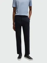 Pantalón de gabardina con corte regular fit, color azul marino, con cierre de botón y cremallera, y bolsillos laterales.