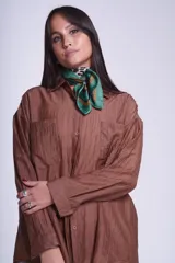 Camisa negra de tela traslúcida con cuello clásico, cierre frontal con botones y dos bolsillos de parche en el pecho.