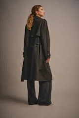 Trench de gamuza color beige, con solapas amplias, charreteras en los puños y cinturón de la misma tela.