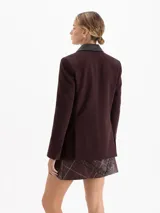 Blazer sastrero color chocolate confeccionado en twill, con solapas de cuero vacuno, bolsillos con tapa y cierre frontal de dos botones.