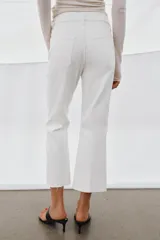 Jeans de tiro medio con corte flare y largo cropped. Presentan diseño de cinco bolsillos, cierre frontal con cremallera y botón, raya planchada en el delantero y bajo desflecado con acabado evasé.