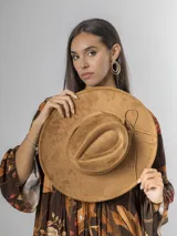 Sombrero de gamuza color tostado, estilo cowboy, con ala ancha y detalle de trenzado en la base de la copa.