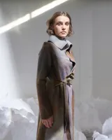 Tapado tipo levita de lana merino afieltrada color visón con matices y acentos de diversas tonalidades armónicas. Tiene forma recta que delinea el cuerpo atada a la cintura con un lazo incorporado, o cruzando las tiras en cuello. Tiene bolsillos laterales.