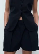 Short negro de tiro medio, corte recto con pinzas delanteras y diseño clásico.