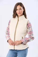 Chaleco de tejido sherpa color beige, con cuello alto y detalles en eco cuero. Diseño sin mangas que proporciona abrigo al torso manteniendo la libertad de movimiento.