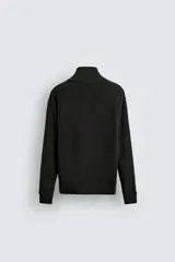 Chaqueta de punto de algodón con textura perlada, corte regular fit, cuello subido y cierre frontal con cremallera. Presenta mangas largas con puños y ruedo en rib.