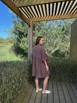 Vestido camisero blanco de lino italiano, con cuello camisero, cierre frontal con botones, mangas cortas con doble volado y bolsillos laterales.