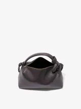 Bolso de mano color negro, con asa corta y cierre superior con cremallera.