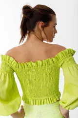 Crop top blanco con escote off-shoulder, punto panal en el torso y volados en el escote.