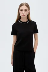 Remera negra de viscosa con cuello redondo decorado con una línea de strass, de mangas cortas y corte ajustado.