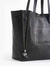 Cartera tipo shopper de cuero vacuno flor graneado, con formato amplio y estructura flexible. Presenta dos cierres verticales decorativos en el frente con tiracierres personalizados y doble manija de hombro.