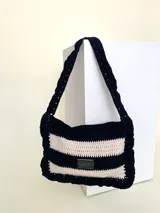 Cartera tejida a crochet con hilo 100% de algodón. Diseño a rayas horizontales en tonos de rojo y rosa, con volados en el borde y en el asa.