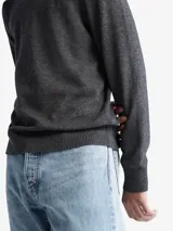 Sweater gris de punto liso, con cuello redondo y mangas largas. Tiene el logo de Calvin Klein bordado en el pecho.