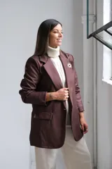 Blazer de corte sastrero en color marrón chocolate, con solapas clásicas, bolsillos delanteros con solapa y costuras a la vista en tono contrastante.