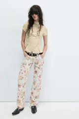 Camisa de manga corta color beige, con cuello alto mao y cierre frontal cruzado con botones.