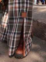 Pantalón a cuadros de corte ligeramente oxford, con cierre y elástico en la cintura, detalle de triángulo de cuero en la pretina y logo bordado en la pierna.