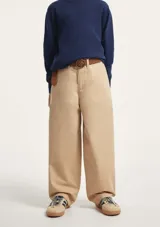 Pantalón de sarga color beige, de corte recto y holgado, con trabillas para cinturón y cierre frontal.
