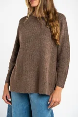 Sweater de punto texturado en color beige, con cuello redondo y mangas largas. Presenta un diseño de tejido acanalado vertical y corte holgado.