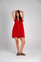 Vestido corto bordó con calados, escote en V y mangas cortas con volados.