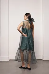 Vestido largo color ocre con estampado de cuadrados dorados, cuello alto y corte amplio. Incluye viso liso al tono.