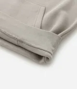 Hoodie cerrado de algodón con felpa, color beige claro, corte comfort. Presenta capucha con cordón ajustable, bolsillo canguro y puños y ruedo ajustados. Estampa minimalista de montañas en el pecho con líneas en tonos marrón, negro y rosado.