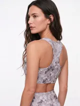 Top deportivo negro con diseño de espalda deportiva y escote redondo.