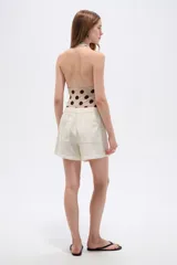 Short de lino color blanco de tiro medio, con bolsillos laterales y cintura elástica con cordón de ajuste.
