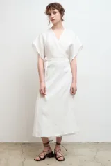 Kimono blanco de lino con corte cruzado, mangas cortas amplias y lazo ajustable en la cintura.