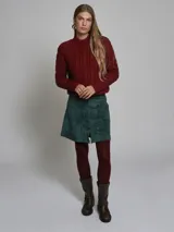 Falda mini color verde esmeralda, de corte recto con cierre frontal de botones.