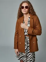 Blazer recto color crudo, de lino, con solapas de muesca, cierre cruzado con doble botonadura, mangas largas y bolsillos con solapa.