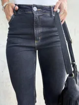 Jean negro de corte recto con lycra, tiro medio y largo a los tobillos.