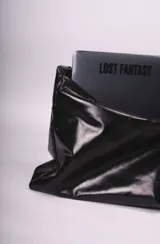 Bolso tipo hobo de cuero negro con correa ancha para el hombro.