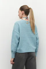 Sweater tramado color lila de manga larga con puños elastizados.