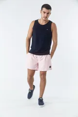 Short de baño liso con cintura elástica y cordón de ajuste. Cuenta con dos bolsillos laterales, un bolsillo posterior y un aplique de logo en goma en la pierna.