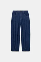 Pantalón de jean azul oscuro con corte tipo ballon, tiro alto, cierre frontal con cremallera y botón metálico, bolsillos delanteros y traseros.