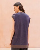Chaleco oversize de punto con hilo lúrex, cuello en V y cierre frontal de botones. Presenta un estampado jacquard con efecto marmolado en tonos marrones y morados, bolsillos frontales aplicados y ribetes en contraste en el escote, sisas y dobladillo.