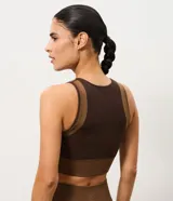 Top deportivo Get Over confeccionado en microfibra seamless de color marrón, con diseño ajustado, escote redondo, sin mangas y recortes contrastantes en tono tostado.