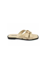 Sandalia plana color beige con punta cuadrada, tiras cruzadas y hebilla metálica dorada decorativa en el empeine.