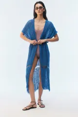 Kimono largo azul de punto calado en algodón, con diseño abierto al frente, hombros caídos, mangas cortas, aberturas laterales y terminación desflecada en el ruedo.