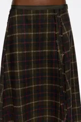 Falda midi de corte línea A, confeccionada en mezcla de lana con estampado de cuadros en tonos verde oscuro, rojo y beige. Presenta cierre lateral oculto, costuras diagonales abiertas y acabados sin rematar en el dobladillo.