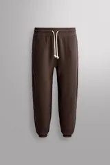 Pantalón jogger relaxed fit de Zara Athleticz confeccionado en tejido de algodón color marrón, con cintura elástica ajustable mediante cordón en contraste, bolsillos laterales y bajo con puño elástico.
