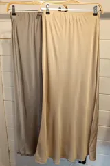 Falda midi de satén en color negro, con corte al bies y caída fluida que se ajusta suavemente a la silueta.