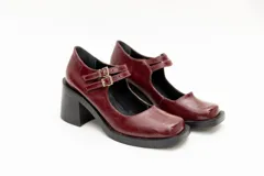 Guillerminas de cuero charol negro con punta cuadrada, taco ancho y correa sobre el empeine con doble hebilla dorada.