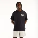 Remera New Balance modelo Foggy Daze 1906 para hombre, de color negro, corte holgado, mangas cortas y cuello redondo. Cuenta con un pequeño estampado frontal con texto y el logo de la marca en el pecho.