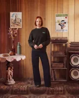 Buzo de cuello redondo en color negro con efecto lavado, de corte regular y ajuste cómodo. Presenta un estampado gráfico en la espalda con motivos de bebidas y texto alusivo, en tonos verde neón y violeta.