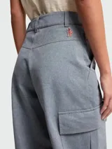 Pantalones de estilo cargo confeccionados en tejido de cambray color gris azulado. Presentan un corte holgado, bolsillos laterales con solapa y cierre frontal con botón y cremallera.